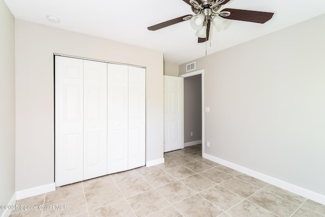 unfurnished bedroom featuring light tile patterned floors, a closet, and ceiling fan