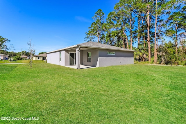 rear view of property featuring a patio area and a lawn