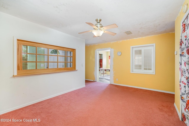 carpeted empty room with ceiling fan and a textured ceiling