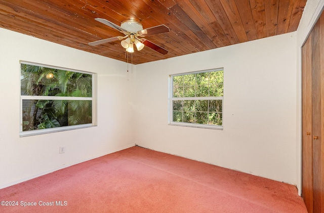 unfurnished room with carpet floors, wooden ceiling, and ceiling fan