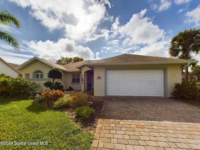 single story home with a garage and a front lawn