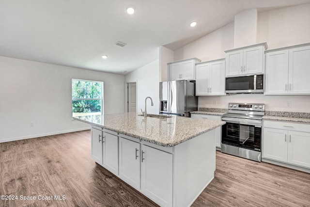 kitchen featuring stainless steel appliances, white cabinetry, a kitchen island with sink, and sink