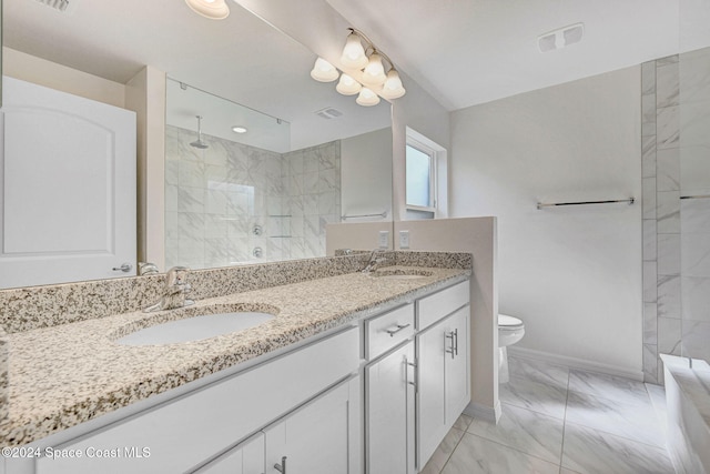 bathroom with vanity, toilet, and a tile shower