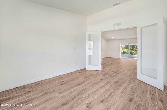 empty room with french doors and light hardwood / wood-style flooring