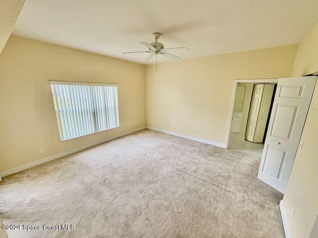 carpeted spare room featuring ceiling fan