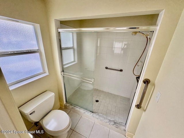 bathroom featuring tile patterned floors, an enclosed shower, and toilet