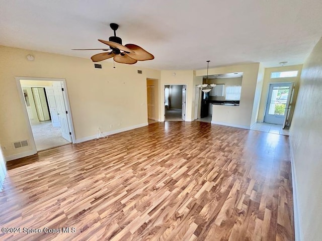 unfurnished living room featuring ceiling fan and light hardwood / wood-style floors