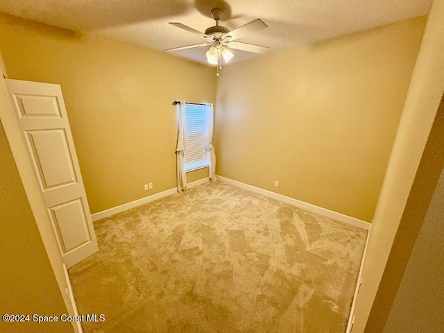 carpeted empty room featuring ceiling fan and a textured ceiling