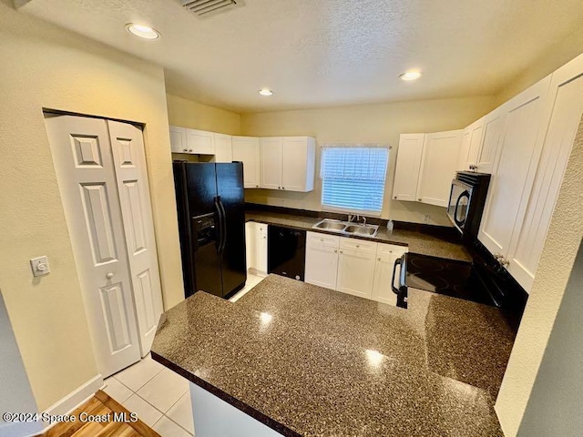 kitchen featuring light tile patterned floors, sink, white cabinetry, and black appliances