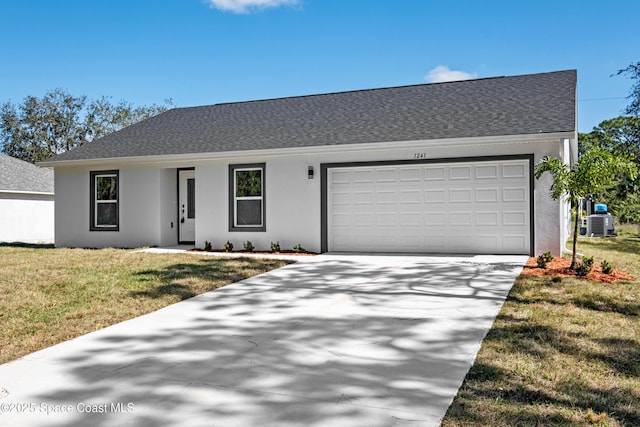 view of front of house featuring cooling unit, a garage, and a front lawn