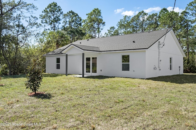 rear view of house featuring a lawn