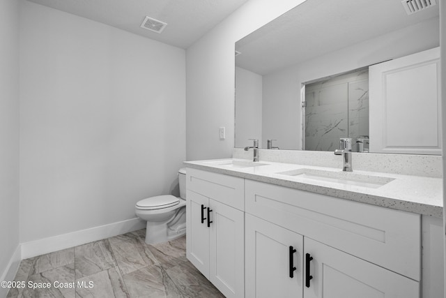 bathroom with toilet, a tile shower, and vanity