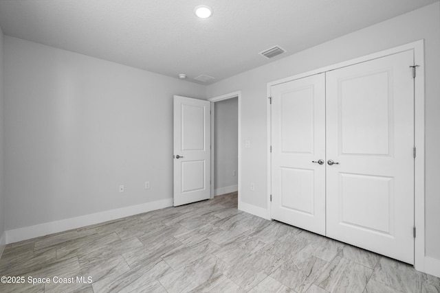 unfurnished bedroom featuring a closet and a textured ceiling