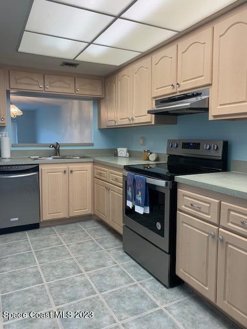 kitchen with light brown cabinets, stainless steel appliances, and sink