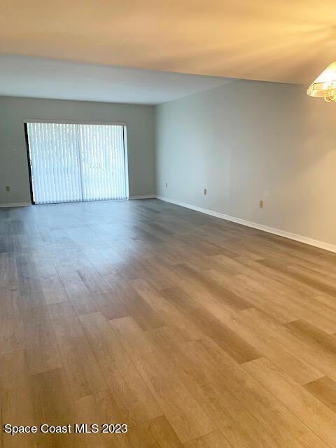 unfurnished room featuring hardwood / wood-style flooring and an inviting chandelier