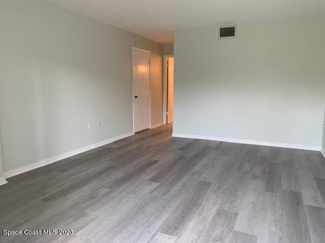 unfurnished room with dark hardwood / wood-style flooring