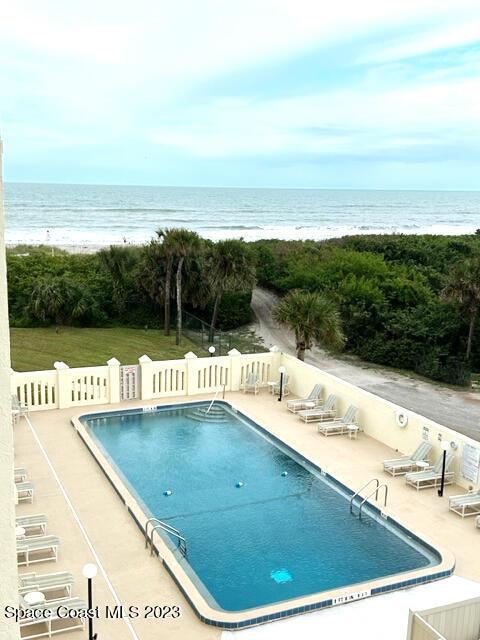 view of pool with a water view and a patio