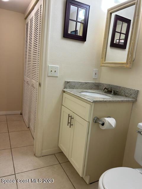 bathroom with tile patterned flooring, vanity, and toilet