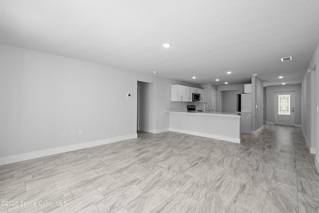 unfurnished living room featuring recessed lighting, a sink, visible vents, and baseboards