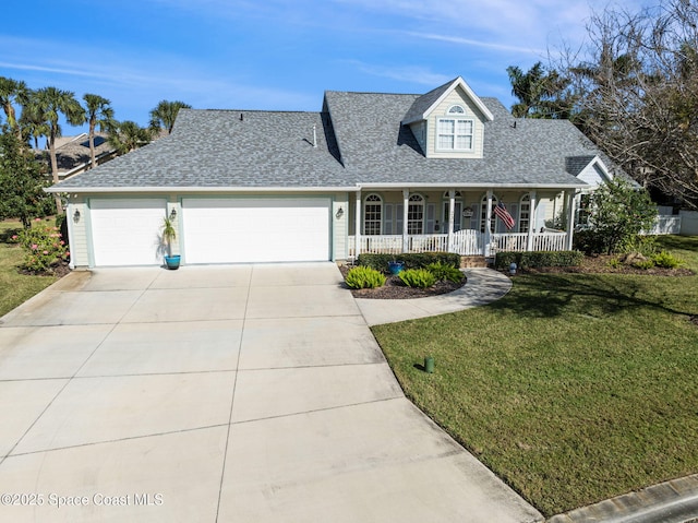 view of front of home featuring a front yard, a garage, and covered porch