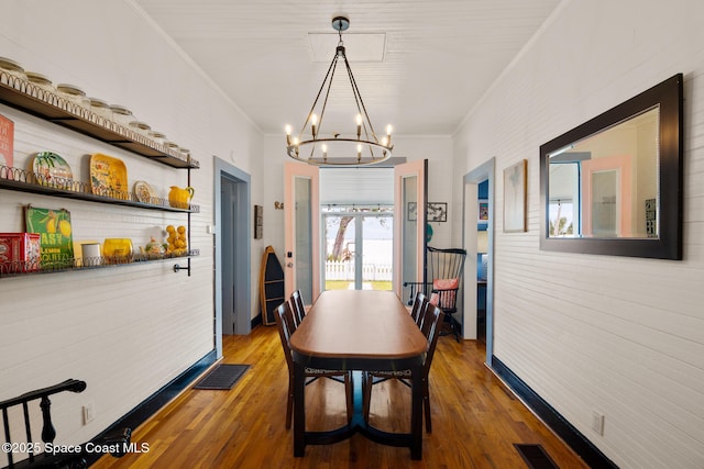 dining room with ornamental molding, a notable chandelier, and wood-type flooring