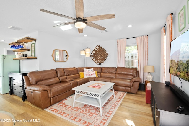 living room with ceiling fan and light hardwood / wood-style flooring