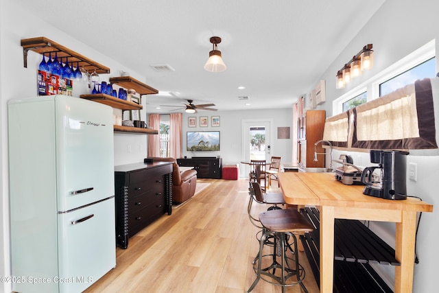 kitchen with white refrigerator, ceiling fan, and light wood-type flooring