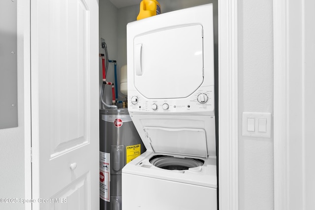 clothes washing area with electric water heater and stacked washer / dryer