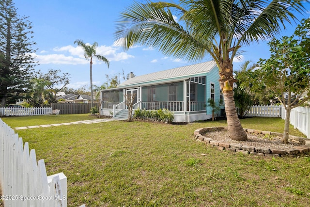 view of front of property featuring a sunroom and a front lawn