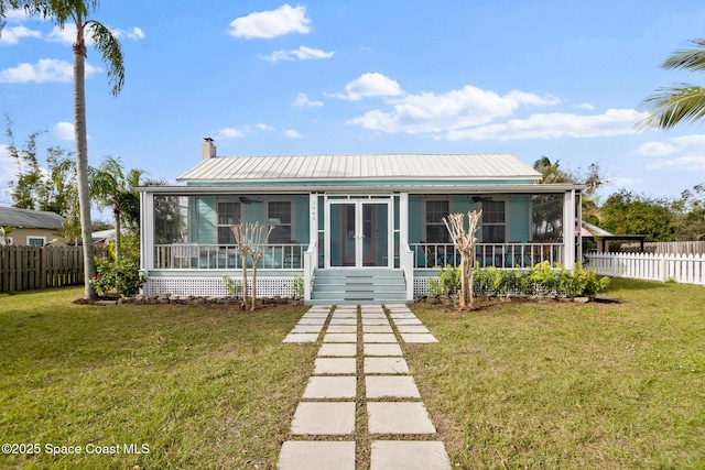 back of house with french doors, a sunroom, and a lawn