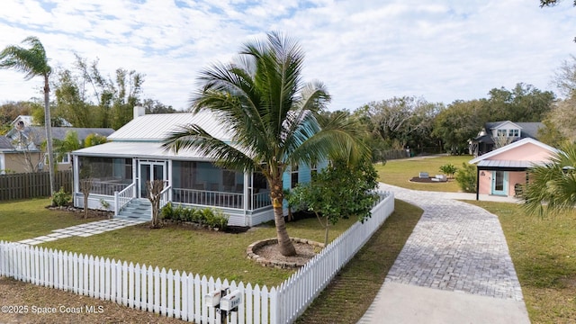 view of front facade with a front yard and a sunroom