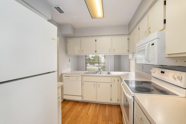 kitchen featuring kitchen peninsula, light hardwood / wood-style floors, white appliances, and sink