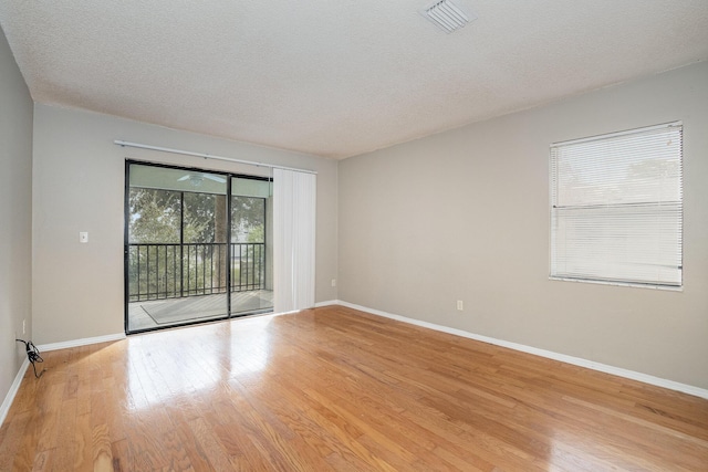 empty room featuring light hardwood / wood-style floors and a textured ceiling