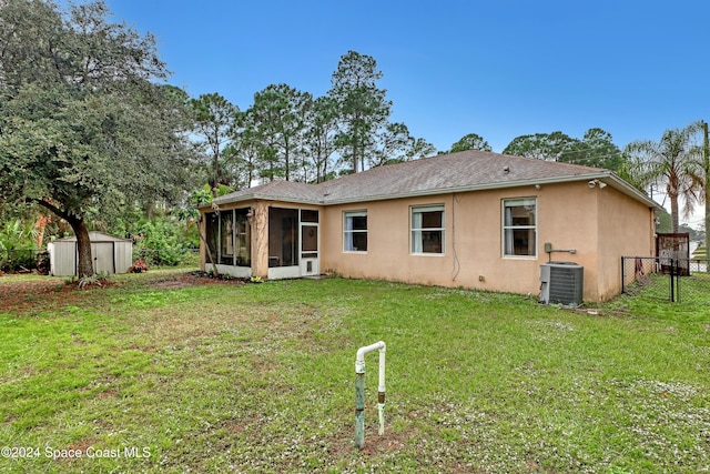 rear view of house featuring cooling unit, a storage shed, and a yard