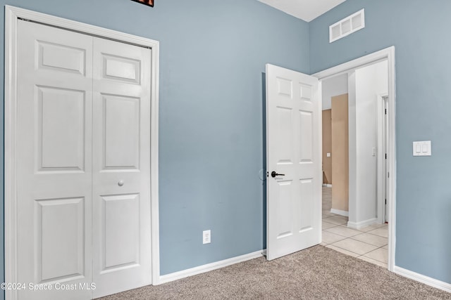 unfurnished bedroom featuring light carpet and a closet