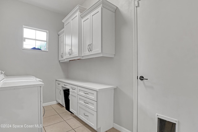 washroom featuring cabinets, separate washer and dryer, and light tile patterned flooring