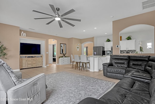 tiled living room featuring ceiling fan