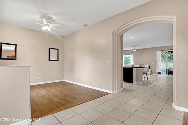 tiled empty room featuring ceiling fan