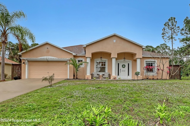 view of front of property with a front yard and a garage