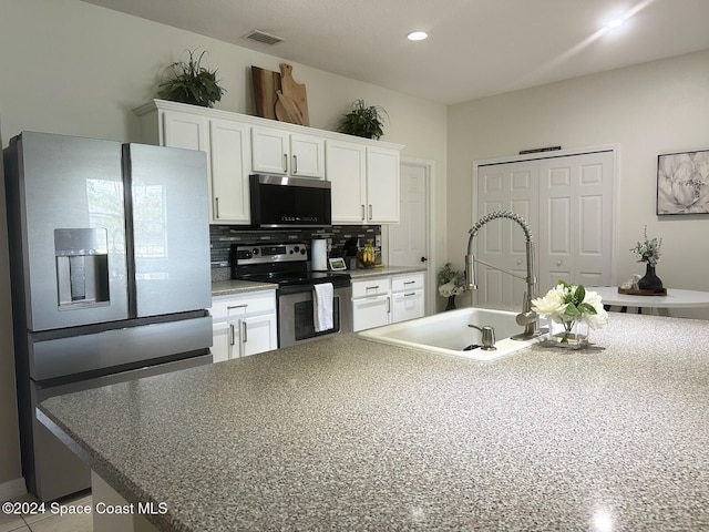 kitchen with white cabinets, appliances with stainless steel finishes, decorative backsplash, and sink