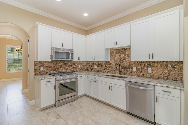 kitchen featuring decorative backsplash, white cabinetry, sink, and appliances with stainless steel finishes