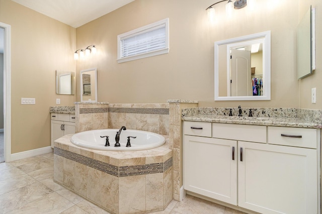 bathroom with vanity and tiled tub