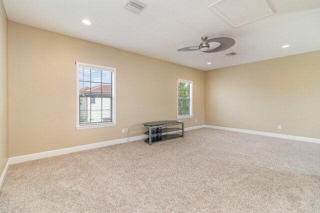 spare room with carpet floors, a wealth of natural light, and ceiling fan