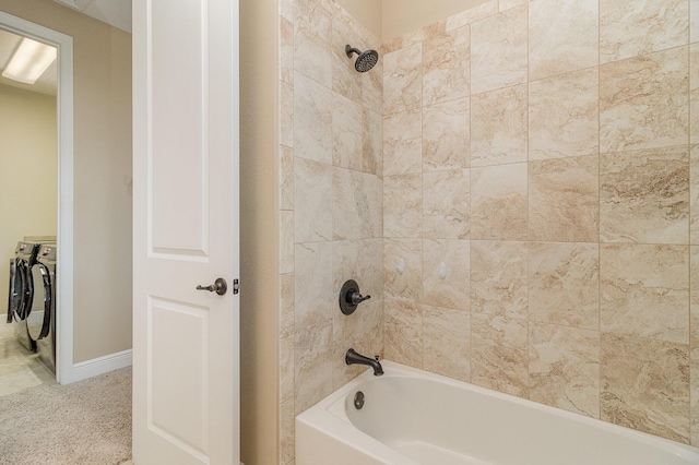 bathroom with tiled shower / bath and washing machine and clothes dryer