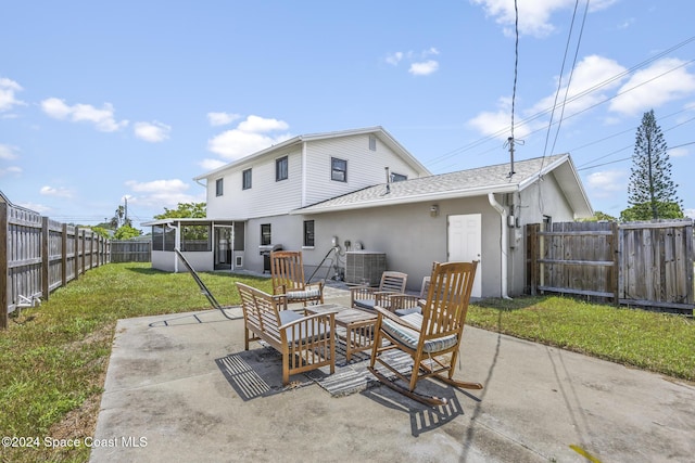 back of property with outdoor lounge area, a sunroom, a yard, cooling unit, and a patio area