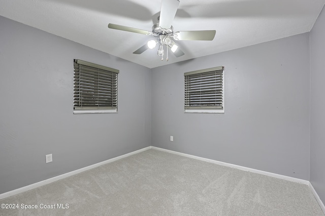 carpeted spare room featuring ceiling fan