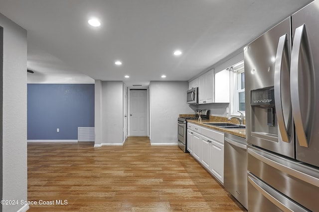 kitchen featuring light hardwood / wood-style floors, sink, white cabinetry, and stainless steel appliances