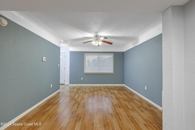 spare room featuring ceiling fan, light hardwood / wood-style flooring, and crown molding