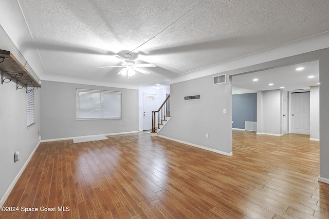 unfurnished living room featuring ceiling fan, a textured ceiling, and light wood-type flooring