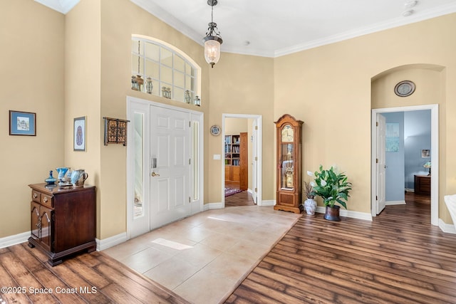 foyer entrance with crown molding and light wood-type flooring